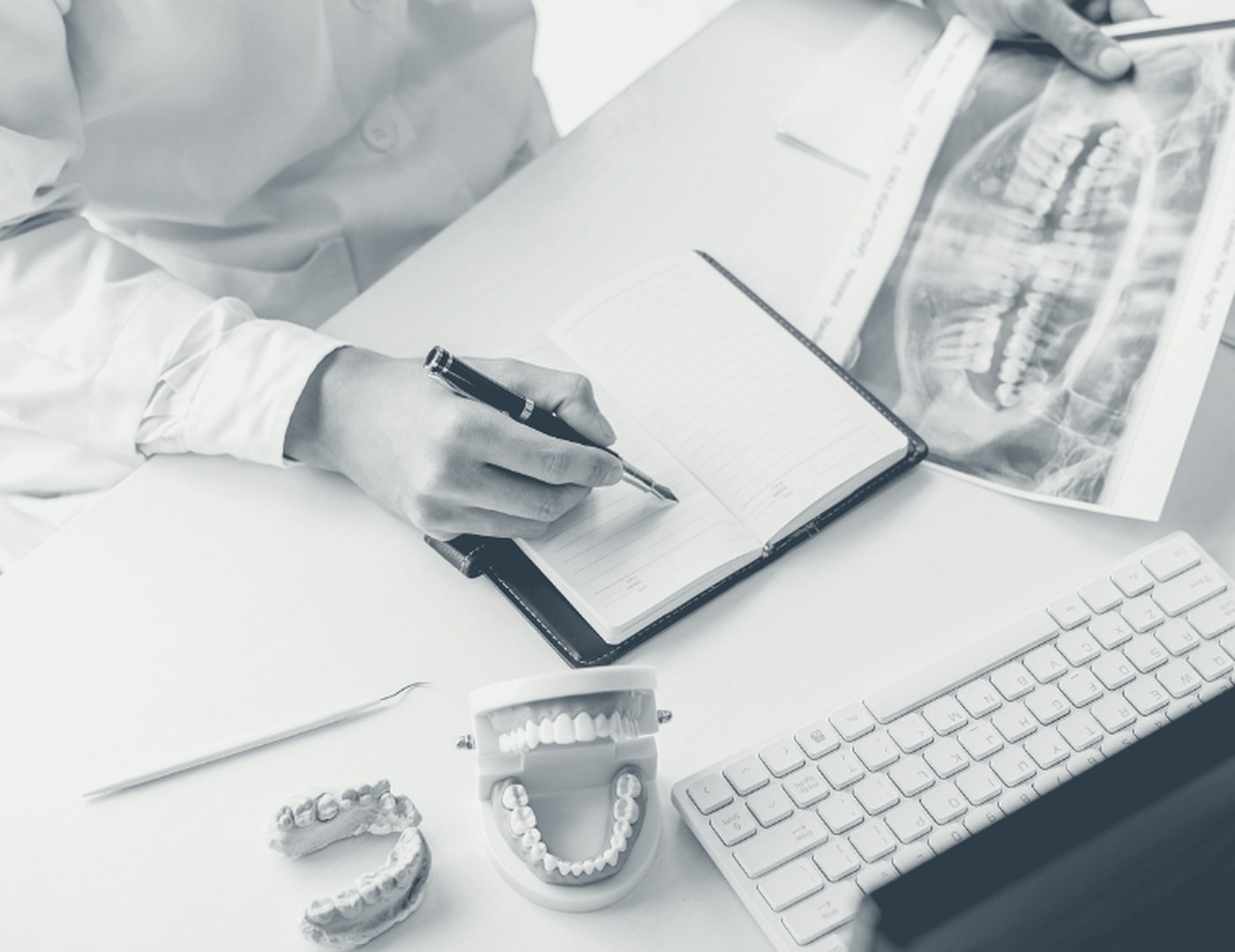 A clinician reading a radiograph and making notes